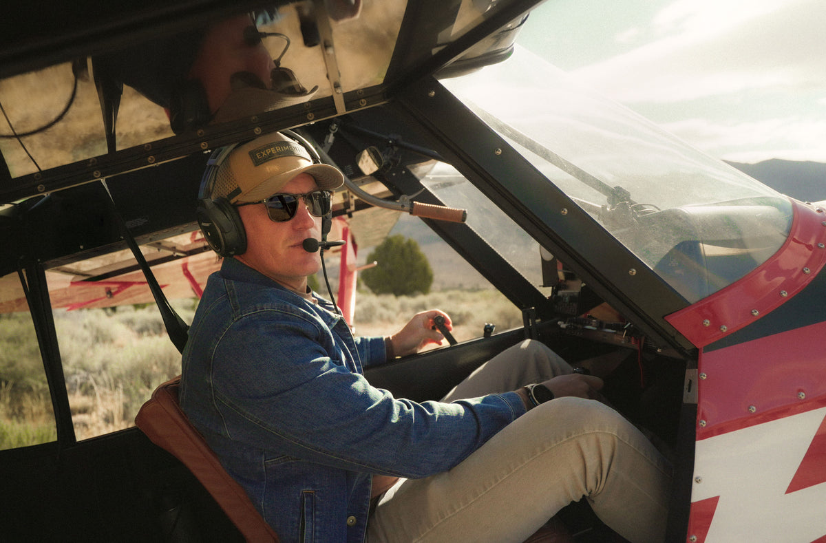 A pilot wearing OTAVI sunglasses at the controls of a backcountry aircraft